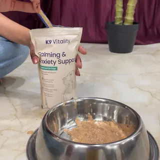 A scoop going into the Calming & Anxiety Support pack, with a bowl of food in front