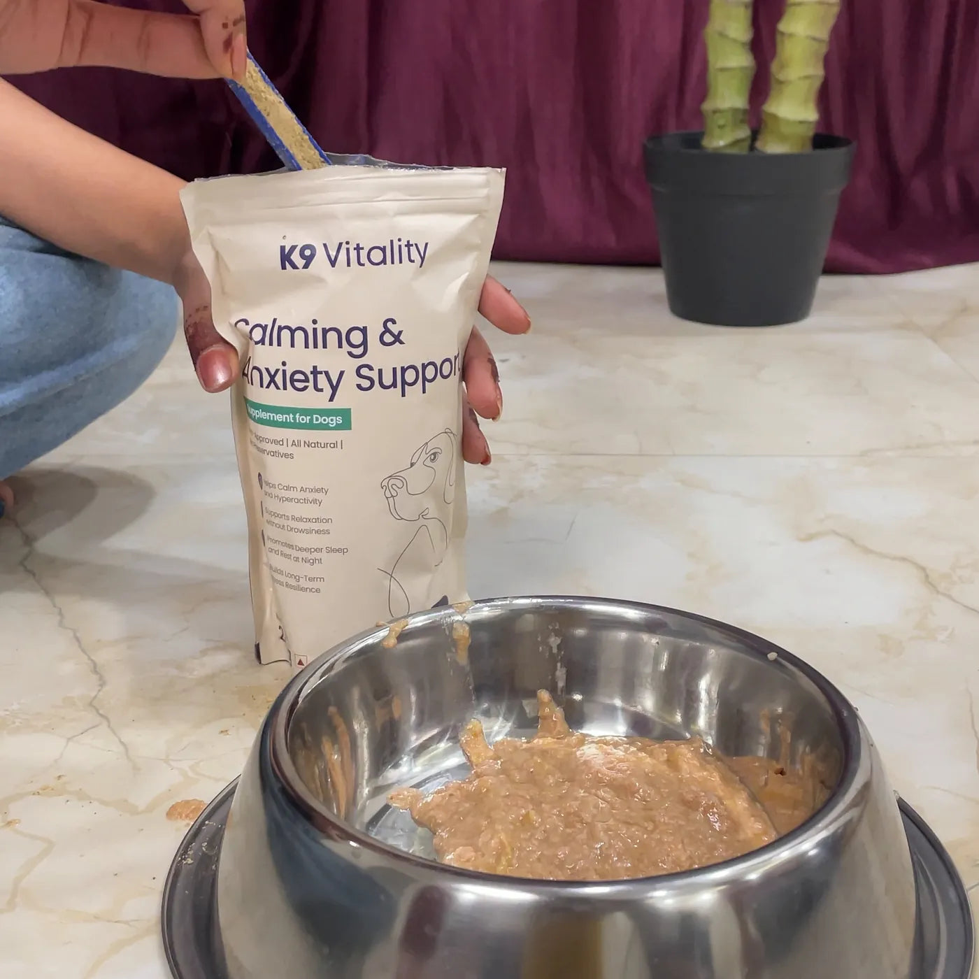 A scoop going into the Calming & Anxiety Support pack, with a bowl of food in front
