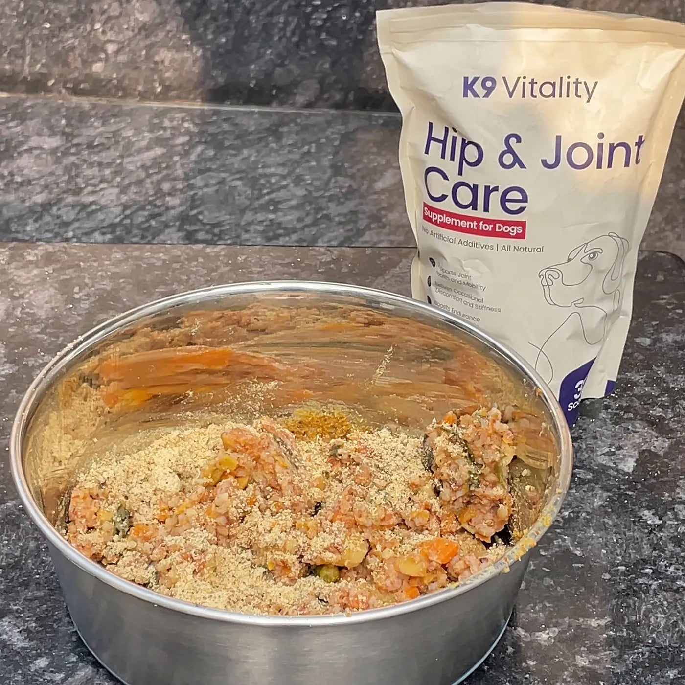 Hip & Joint powder on a bowl of home-cooked food, with the pack beside it on a dark counter